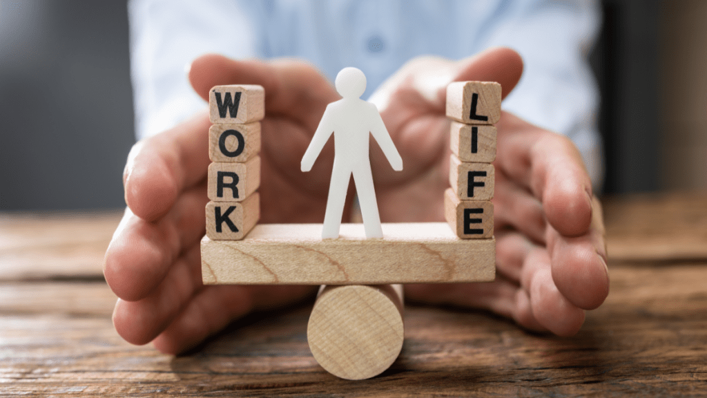 Uomo che tiene una bilancia di legno con le parole "lavoro" e "vita" scritte su di essa, simbolo tangibile dell'importanza della Work-life balance