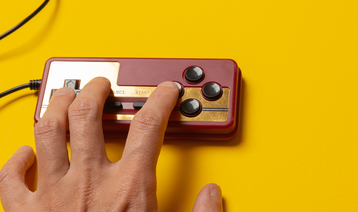 Mano che gioca con un joystick durante una sessione di gamification