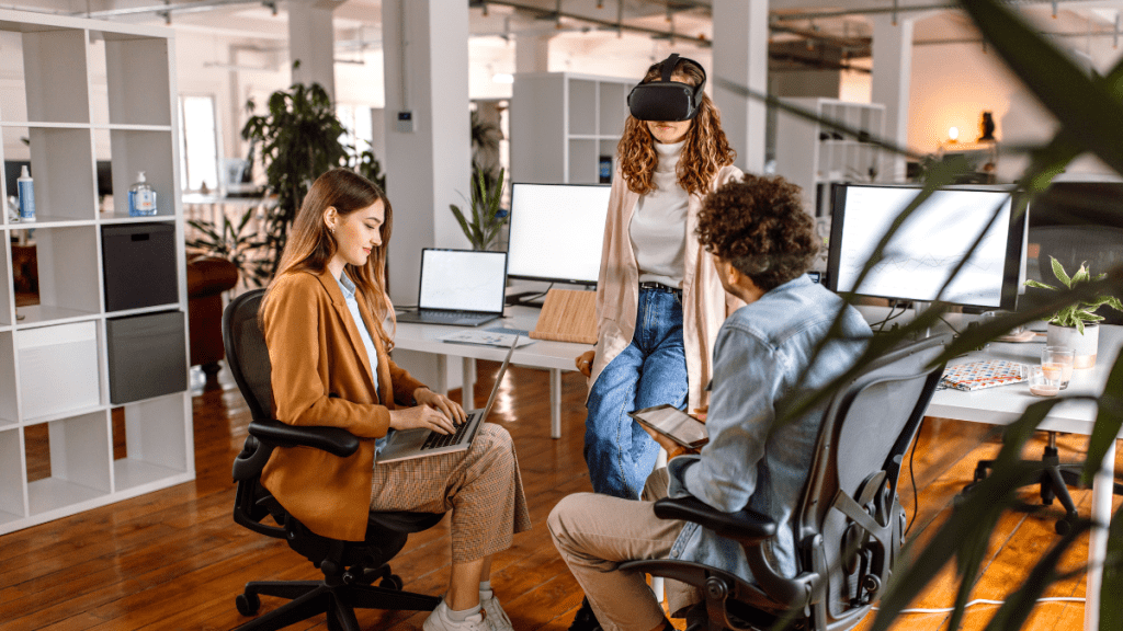 Gruppo di tre colleghi che gioca con uno strumento di realtà aumentata durante una sessione di gamification