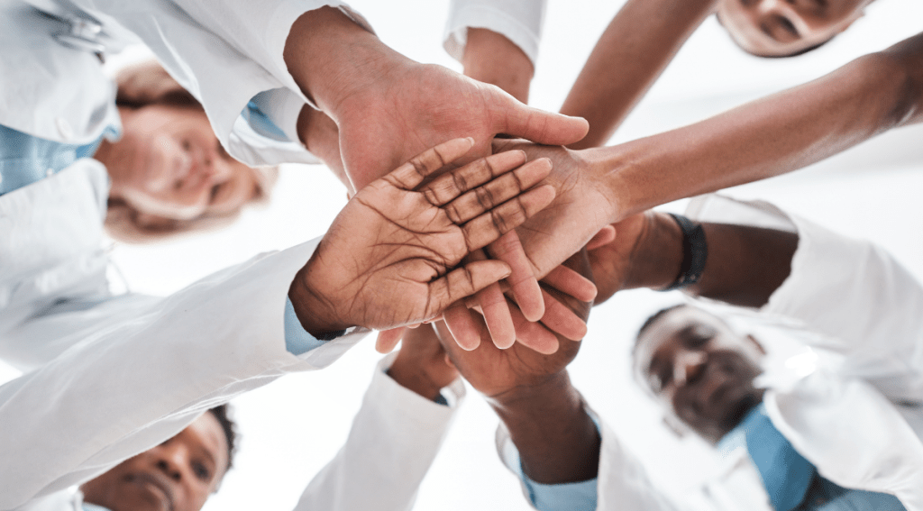 Team di lavoro che si dà la mano, simbolo di collaborazione e fiducia in una Skill-Based Organization