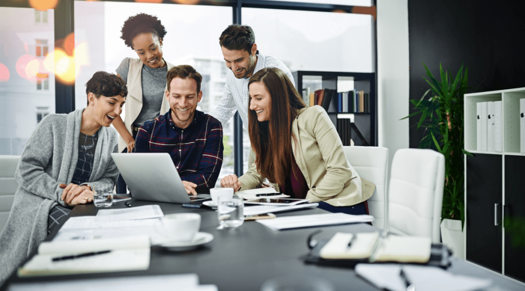 Team di lavoro che collabora davanti a un computer, esempio di comunicazione efficace e teamwork nel lavoro moderno