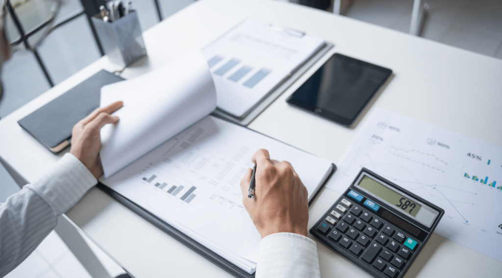 Manager analizza report con grafici e calcolatrice per monitorare obiettivi, risultati e accountability nel team.