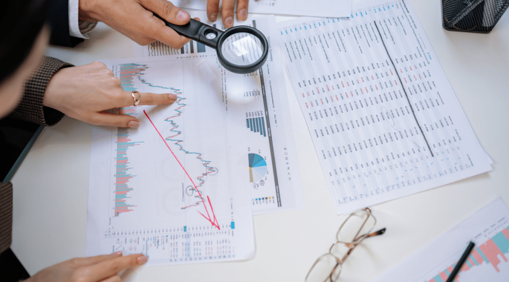 Analisi di grafici e dati con lente di ingrandimento, simbolo di controllo della validità psicometrica negli strumenti di assessment.